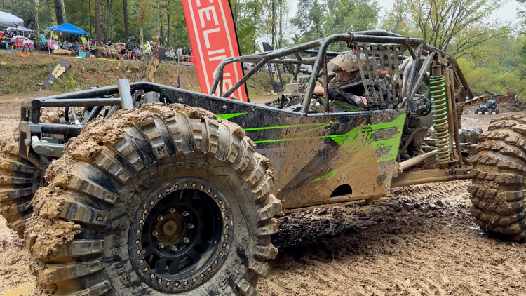 Green rock bouncer climbing through the mud